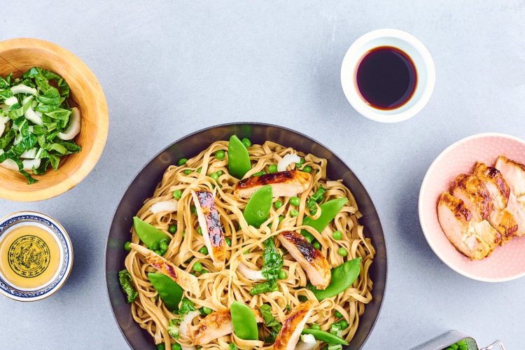 Wok de nouilles sautées au poulet, petits pois et pois gourmands