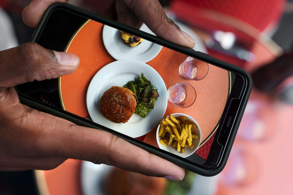 téléphone prenant en photo des plats au restaurant