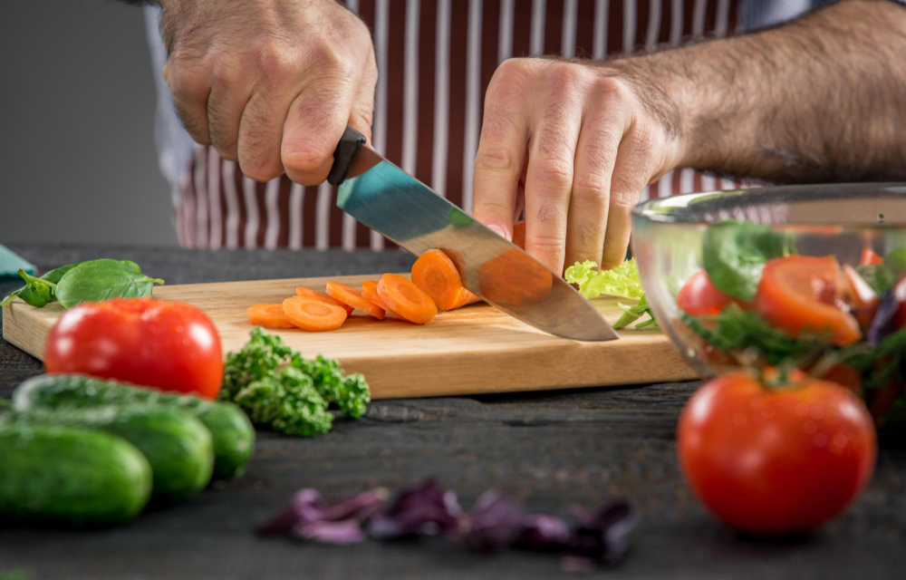 un homme coupant des légumes