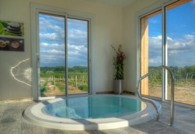 Jacuzzi rond baies vitrées vu sur vignoble