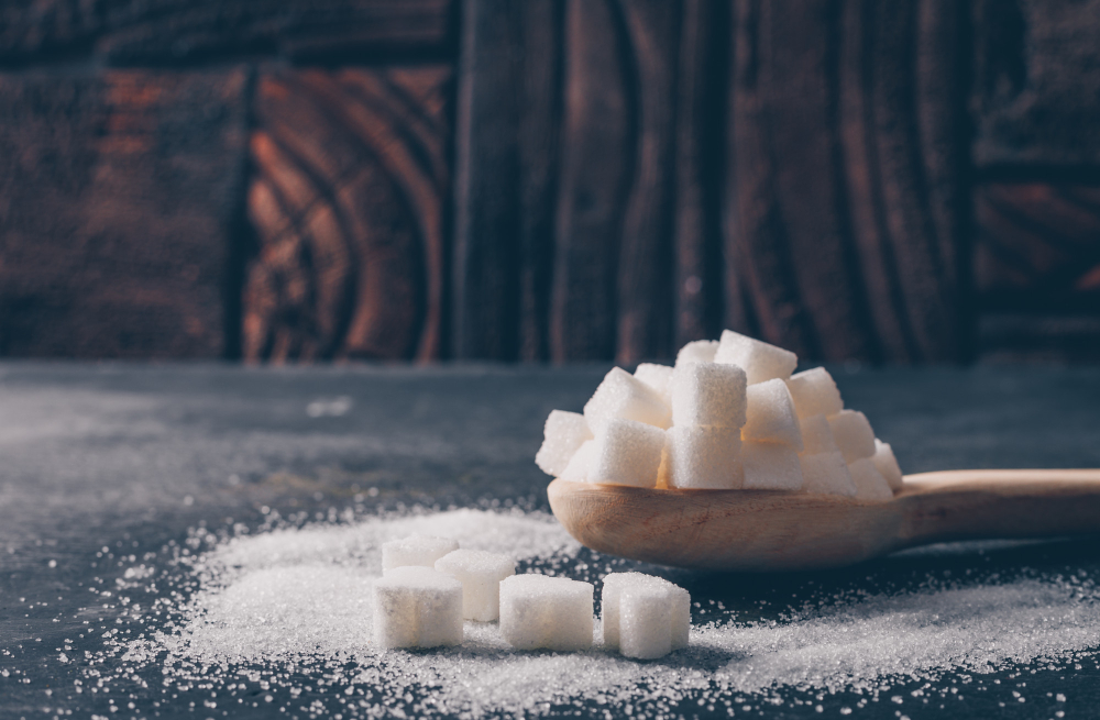 Des morceaux de sucres sur une cuillère en bois.