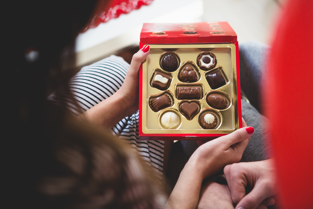 une femme ouvrant une boite de chocolat