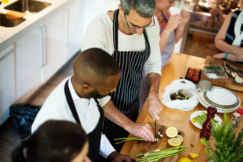 Homme découpant des légumes lors d'un cours de cuisine