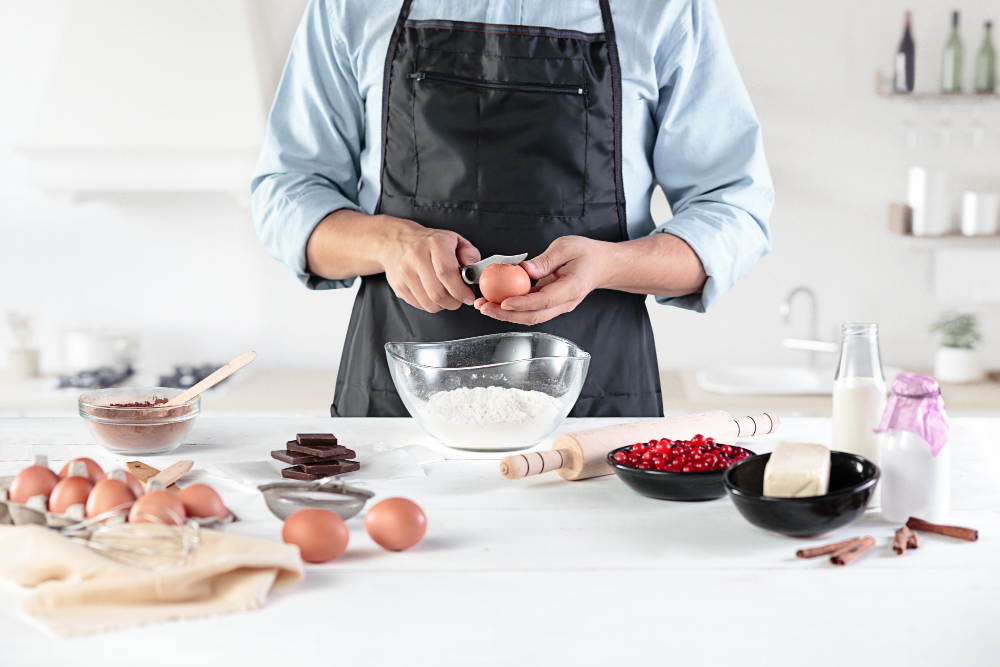 un pâtissier qui casse des oeus