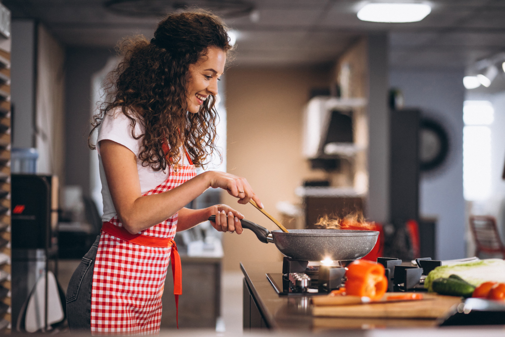 une femme qui cusine avec un tablier