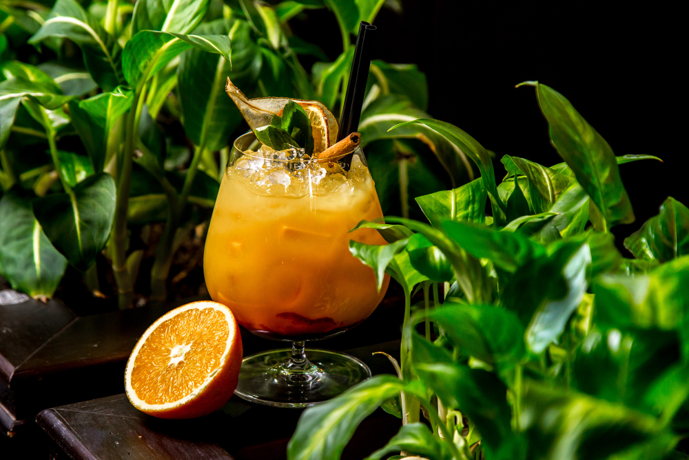 un cocktail jaune entouré de verdure