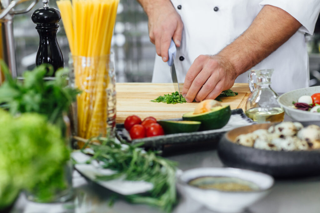 un homme qui découpe des légumes