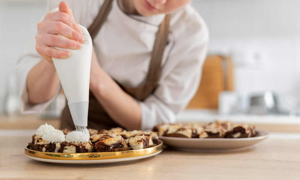 Pâtissière qui met du nappage sur un gâteau 