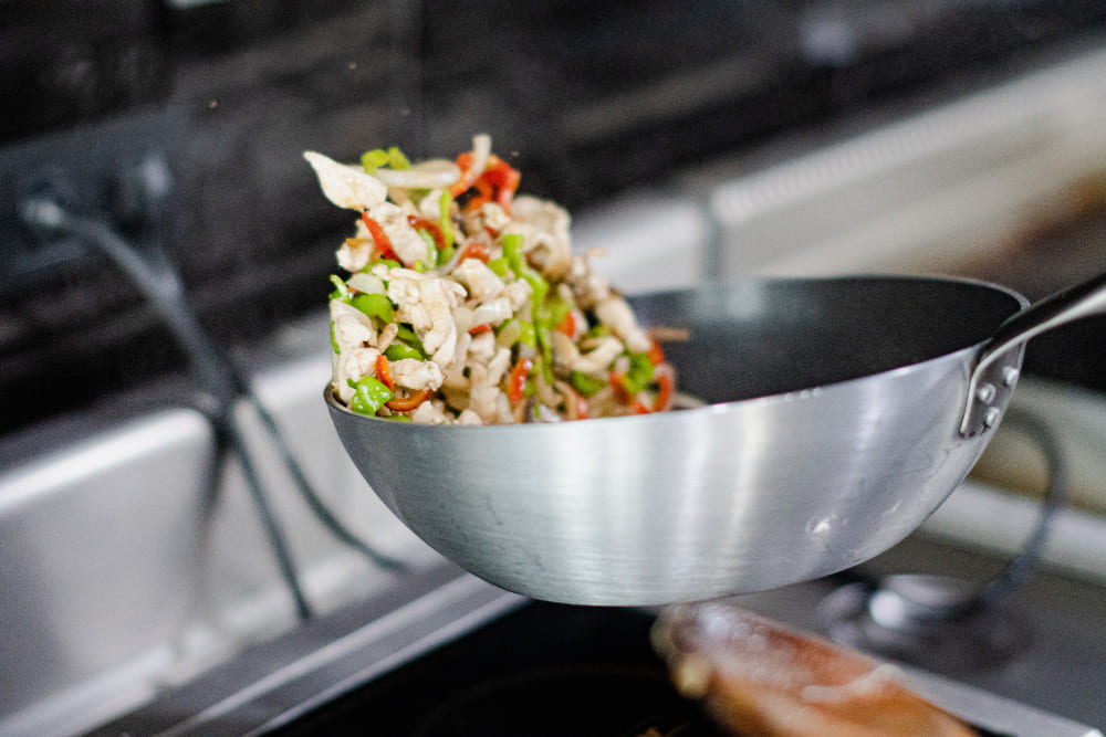 Cussion sauté avec un wok en inox